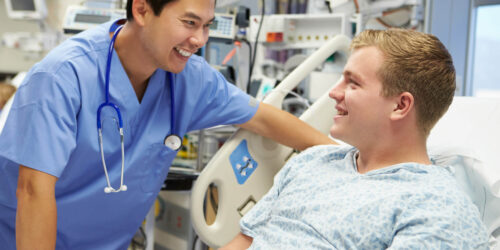 Young Male Patient Talking To Male Nurse In Emergency Room