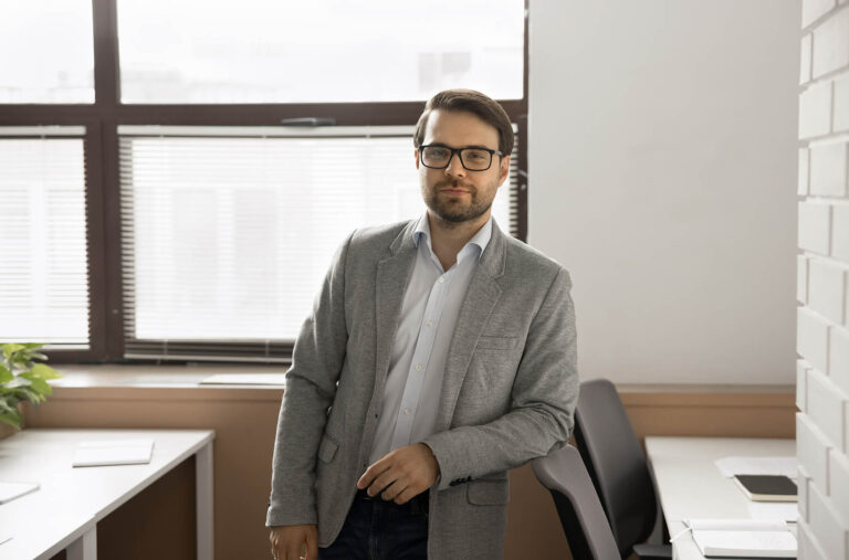 Millennial,Professional,Businessman,,Wearing,Eyeglasses,And,Jacket,Standing,Confidently,In