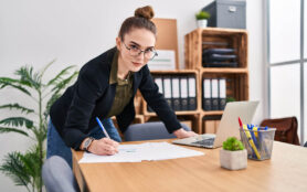 Young,Woman,Business,Worker,Writing,On,Document,At,Office